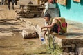 Indian girl pouring water into bottle on the street in Bundi. India