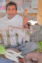 BUNDI, RAJASTHAN, INDIA - DECEMBER 08, 2017: Portrait of a seller holding a traditional pair of scales at the vegetable market