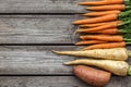 Bundle of carrots, parsnip and sweet potato on a rustic table Royalty Free Stock Photo