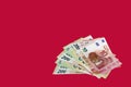 Bundle of cash money,10,50,100,200 Euro paper banknotes ,column of various stacked Euro coins on them on red background Royalty Free Stock Photo