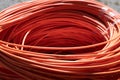 Bundle of coiled orange fiber optic cables on the street Royalty Free Stock Photo