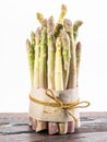 Bundle of cultivated white asparagus on wooden board. White background