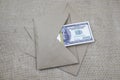 A bundle of 100 dollar bills lies in a brown envelope on a pile of envelopes Royalty Free Stock Photo