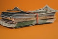 bundle of dollars lying on orange background close up