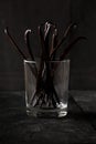 Bundle of dried bourbon vanilla beans or pods in glass on black wood background Royalty Free Stock Photo