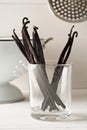 Bundle of dried bourbon vanilla beans or pods in glass on white kitchen background