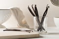 Bundle of dried bourbon vanilla beans or pods on wooden cutting board and in glass on white kitchen background