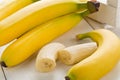 Bundle of fresh, ripe, yellow bananas with sliced banana pieces