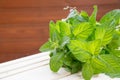 Bundle of fresh spear mint isolated on wooden background.Green mint leaves bunch.peppermint in bowl, leaves herb on