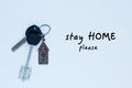 Bundle of keys with a keychai in in the form of a house. Inscription stay home please Royalty Free Stock Photo