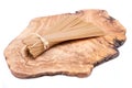 Bundle of Organic uncooked Brown Rice Spaghetti pasta tied with straw on a natural olive wood cutting board .