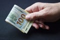 Bundle of rolled up dollar bills clutched in caucasian  man`s hand. Male holding cash money currency of United States Royalty Free Stock Photo