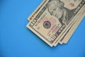 Bundle of ten dollar bills banknotes on blue background Royalty Free Stock Photo