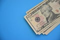 Bundle of ten dollar bills banknotes on blue background Royalty Free Stock Photo