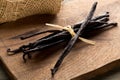 Bundle of tied, dried bourbon vanilla beans or pods on brown wooden cutting board Royalty Free Stock Photo