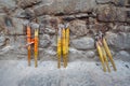 Bundles of incense sticks leaning against a stone wall at a Chinese temple