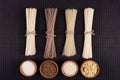 Bundles raw noodles with ingredient in wooden bowls on black striped mat background with copy space, top view. Royalty Free Stock Photo