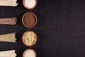 Bundles raw noodles with ingredient in wooden bowls on black striped mat background with copy space, top view. Royalty Free Stock Photo