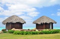 Two bungalows in front of turquoise sea.