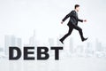 Bunkrupt concept with businessman running from debt word at city Royalty Free Stock Photo