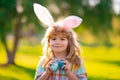 Bunny child boy face. Child boy hunting easter eggs. Child boy with easter eggs and bunny ears in park.