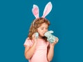 Bunny child. Child boy hunting easter eggs. Child boy with easter eggs and bunny ears isolated on blue background. Funny