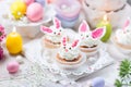 Bunny cupcakes with white cream, flowers and colorful eggs Royalty Free Stock Photo