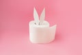 Bunny ears out of white toilet paper roll on pastel lifht pink background. Easter funny trendy rabbit concept. Side view Royalty Free Stock Photo