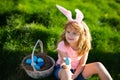 Bunny easter child. Kids hunting easter eggs. Boy with easter eggs and bunny ears in backyard. Easter holiday.