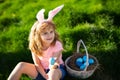 Bunny easter child. Kids hunting easter eggs. Boy with easter eggs and bunny ears in backyard. Easter holiday.