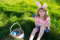 Bunny easter child. Kids hunting easter eggs. easter basket Boy with easter eggs and bunny ears in backyard.
