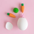 Bunny hatching from eggshell and vegetables abstract on rose