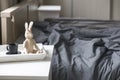 bunny on hinges made of unpainted wood and a cup of coffee on a tray are on the bedside table Royalty Free Stock Photo