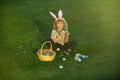 Bunny kids with rabbit bunny ears. Easter egg hunt in garden. Child boy playing in field, hunting easter eggs. Royalty Free Stock Photo