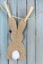 Bunny shape in burlap with a cotton swab tail hanging from twine by clothespins.