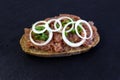 Buns with minced pork sausage, german mettwurst with onions and parsley garnish on a breakfast table with a slate board Royalty Free Stock Photo