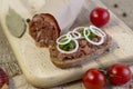 Buns with minced pork sausage german mettwurst with onions and parsley garnish on a breakfast table with a wooden board Royalty Free Stock Photo