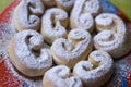 Buns sprinkled with powdered sugar on a red plate.