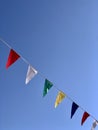 Bunting with colorful triangular flags against blue sky Royalty Free Stock Photo