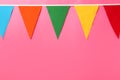 Bunting with colorful triangular flags on pink background. Space for text