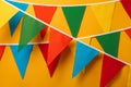 Buntings with colorful triangular flags hanging on orange background. Festive decor Royalty Free Stock Photo