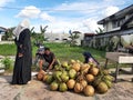 Buntok, Indonesia. March 27, 2023. The coconut seller is peeling coconuts ordered by a buyer.