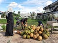 Buntok, Indonesia. March 27, 2023. The coconut seller is peeling coconuts ordered by a buyer.