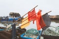 Buoy flag makers on poles above rope and fishing next baskets in Whitstable harbour. Fisherman huts and fishing boats can be seen Royalty Free Stock Photo