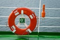 Buoy or lifebuoy ring on shipboard in evening sea. Flotation device on ship side on seascape. Safety, rescue, life preserver.