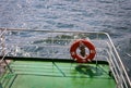 Buoy or lifebuoy ring on shipboard in evening sea. Flotation device on ship side on seascape. Safety, rescue, life preserver. Royalty Free Stock Photo