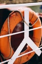 Buoy or lifebuoy ring on shipboard in evening sea. Flotation device on ship side on seascape. Safety, rescue, life Royalty Free Stock Photo