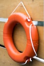 Buoy or lifebuoy ring on shipboard in wooden background. Flotation device on ship side on seascape. Safety, rescue, life preserver Royalty Free Stock Photo