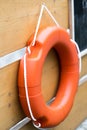 Buoy or lifebuoy ring on shipboard in wooden background. Flotation device on ship side on seascape. Safety, rescue, life preserver