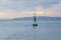 A buoy in the sea, in the background cargo ships and the coast. Royalty Free Stock Photo